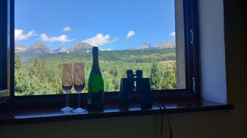a window sill with wine glasses and wine bottles at Apartman Lunette in Tatranska Strba