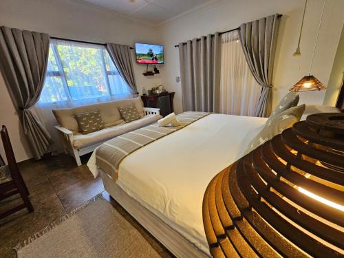 a bedroom with a large bed and a couch at Leopard Corner Lodge in St Lucia