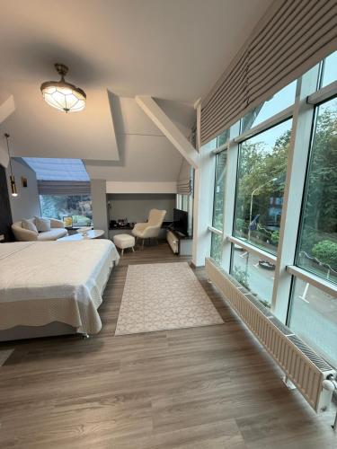 a bedroom with a bed and large windows at Hotel Maria in Rădăuţi