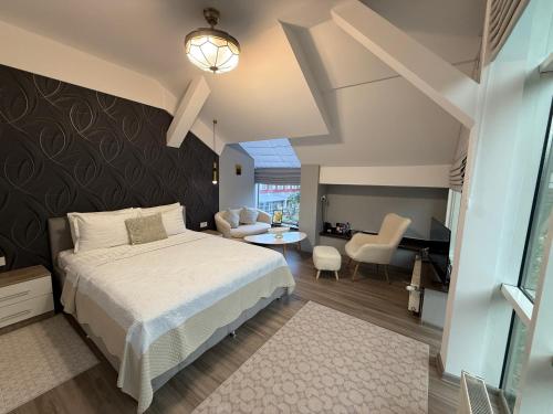 a bedroom with a bed and a living room at Hotel Maria in Rădăuţi