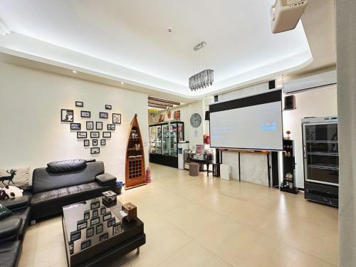 a living room with a couch and a large screen at 幸福滿屋民宿-包棟詢問 in Hualien City