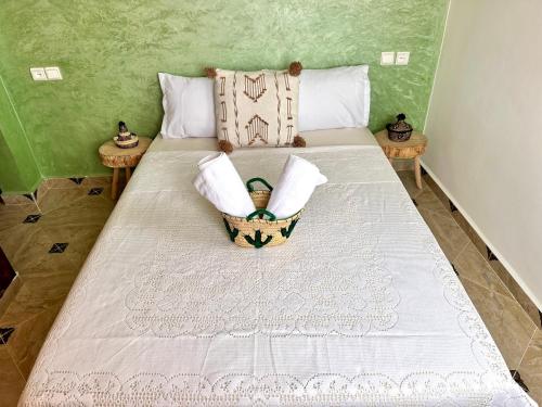 a bedroom with a bed with a basket on it at Balance Surf Morocco , Quality rooms , Moroccan food , Activities in Aourir