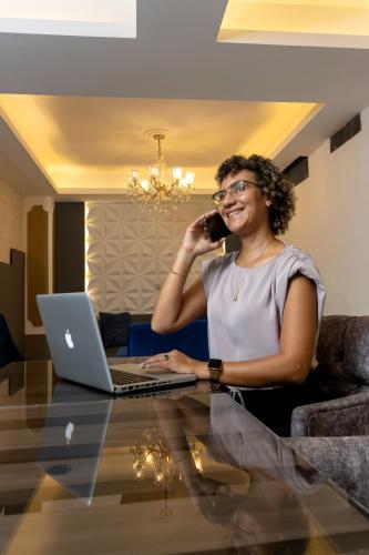 a woman talking on a cell phone in front of a laptop at Hotel Presidente Internacional in Guayaquil