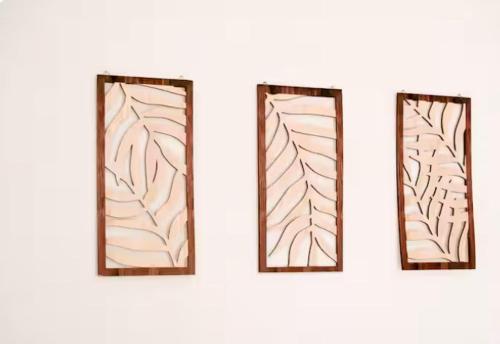 three stained glass windows with brown frames on a wall at L'écrin rose, appartement coeur de ville de Bergerac in Bergerac