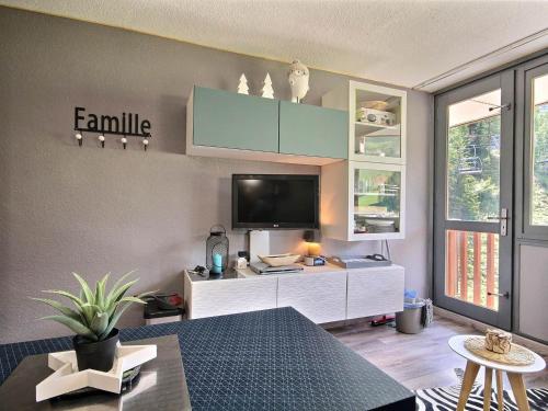 un salon avec une télévision sur un mur dans l'établissement Studio cabine rénové à Plagne Centre avec balcon et proche des pistes - FR-1-455-68, à La Plagne
