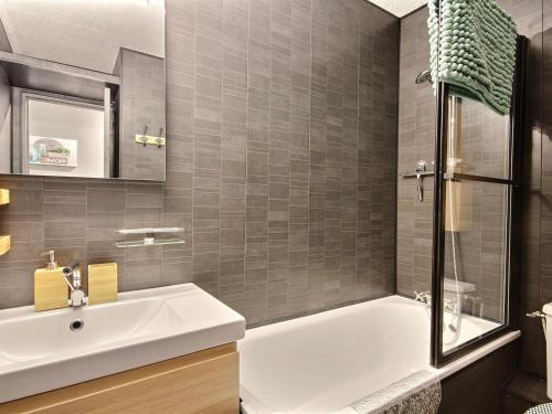 une salle de bain avec une baignoire blanche et un lavabo dans l'établissement Studio cabine rénové à Plagne Centre avec balcon et proche des pistes - FR-1-455-68, à La Plagne