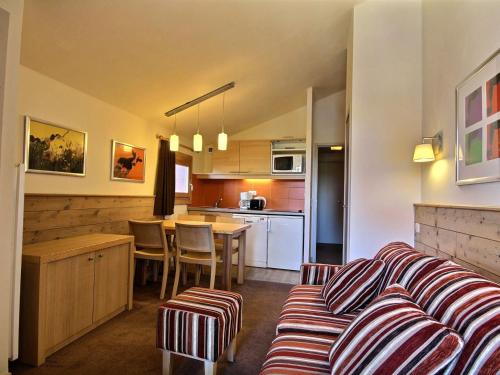 un salon avec un canapé et une cuisine dans l'établissement Studio-cabine chaleureux pour 4 pers. à 50m des pistes, balcon, ascenseur - FR-1-455-179, à La Plagne Tarentaise