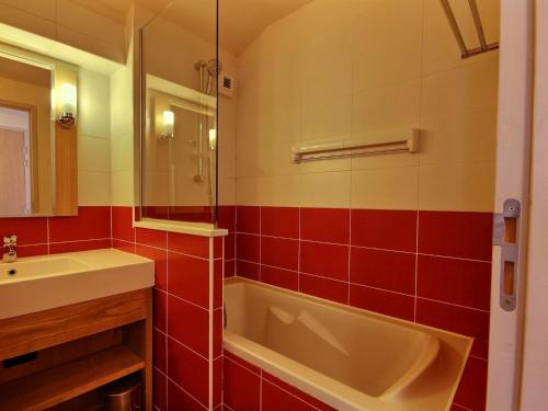 une salle de bain avec une baignoire et un lavabo dans l'établissement Studio-cabine chaleureux pour 4 pers. à 50m des pistes, balcon, ascenseur - FR-1-455-179, à La Plagne Tarentaise