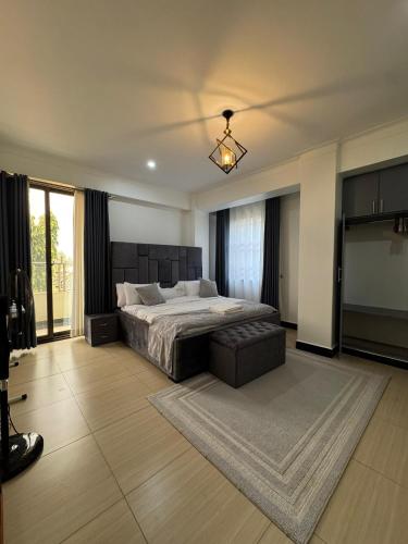 a bedroom with a large bed and a couch at Bukoto Villa apartment in Bukoto