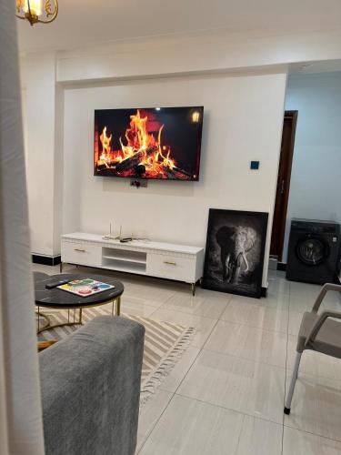 a living room with a flat screen tv on the wall at Bukoto Villa apartment in Bukoto