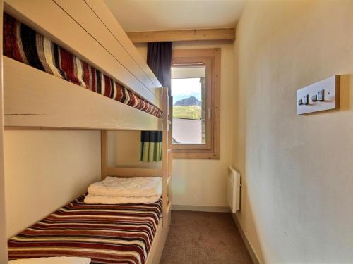 une petite chambre avec deux lits superposés et une fenêtre dans l'établissement Studio cabine chaleureux, 4 pers, balcon, vue montagnes, près des pistes, spa - FR-1-455-184, à La Plagne Tarentaise