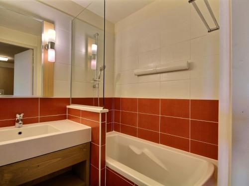 une salle de bain avec un lavabo, une baignoire et un miroir dans l'établissement Joli studio-cabine pour 4 avec cuisine équipée à Belle Plagne - FR-1-455-192, à La Plagne Tarentaise