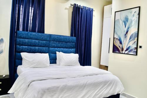 a bed with a blue headboard in a room at 5 Bedroom semi detached Apartment by Ellestar Homes in Lekki