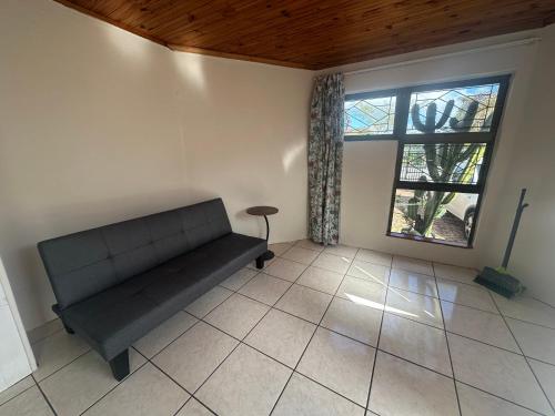 a living room with a couch and a window at Suite Dreams Adorable One Bedroom Apartment in Panorama