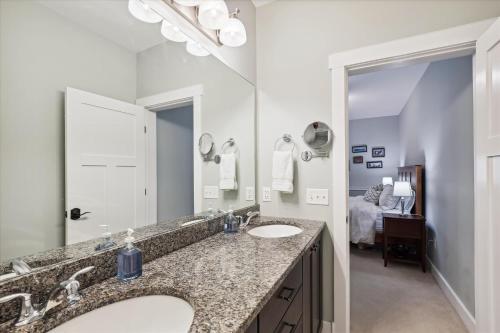 a bathroom with two sinks and a large mirror at Base Camp at Village Walk E in Stowe