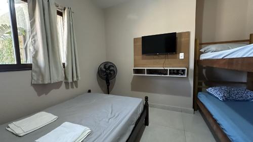 a room with two bunk beds and a flat screen tv at Sítio em confins, com Piscina e hidro aquecida in Confins