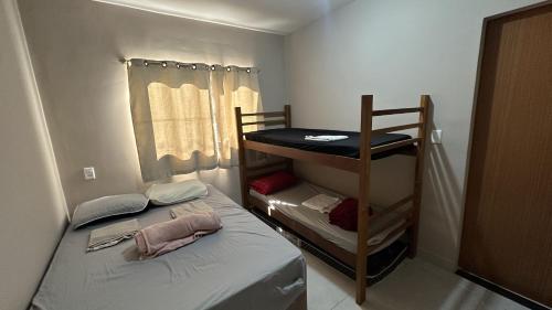 a small room with a bed and a bunk bed at Sítio em confins, com Piscina e hidro aquecida in Confins