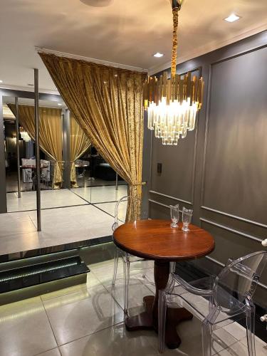 a dining room with a table and a chandelier at Motel Casa de Pedra in Caràzinho