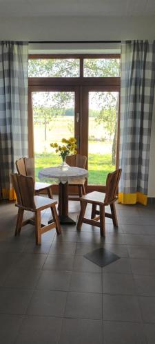 a room with a table and two chairs and a table and a window at Gospodarstwo Agroturystyczne Bogdanówka in Rossosz