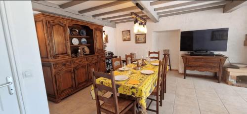 une salle à manger avec une table avec des chaises et une télévision dans l'établissement F4 house with Wifi and private pool in Vidauban, à Vidauban