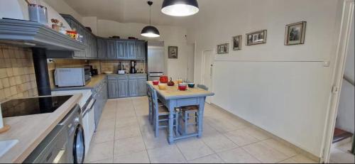une cuisine avec des placards bleus et une petite table. dans l'établissement F4 house with Wifi and private pool in Vidauban, à Vidauban