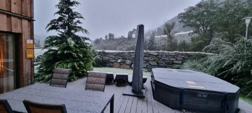 a patio with a grill and a table and chairs at Wellness Chalet Bell a Mur in Murau