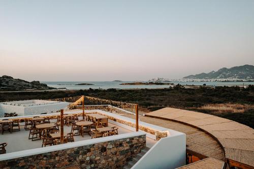 a restaurant on the beach with tables and chairs at Laguna Coast Resort, Small Luxury Hotels of the World in Stelida