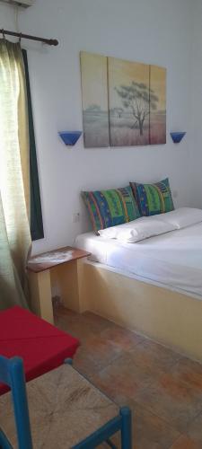 a room with two beds and a chair and a window at Γοργονα in Milína