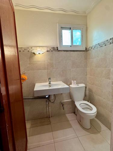 a bathroom with a toilet and a sink at Évasion à deux pas de la mer in Saïdia