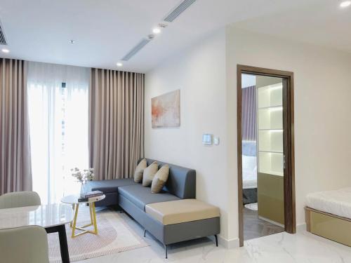 a living room with a blue couch and a table at 1BR Supper King View Vip Luxury in Long Bình