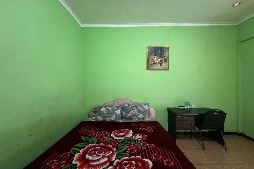 a green room with a bed and a desk and a bed sidx sidx sidx at OYO 94714 Khayla Homestay Syariah in Yogyakarta