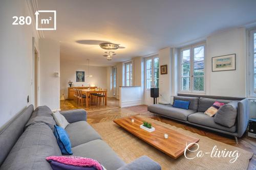 a living room with a couch and a table at Bedroom 4 - Yesterday's Charm - COLIVING in Ferney-Voltaire