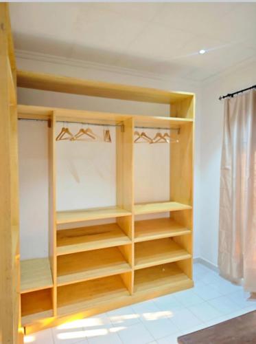 a closet with wooden shelves in a room at HK Residence in Bangui