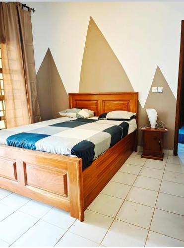 a bedroom with a bed with geometric shapes on the wall at HK Residence in Bangui