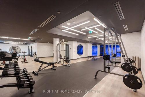 a gym with several treadmills and machines in it at Brand-New Mississauga Condo! in Mississauga
