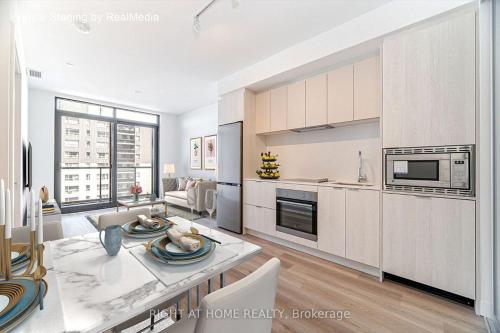 a kitchen and living room with a table and chairs at Brand-New Mississauga Condo! in Mississauga