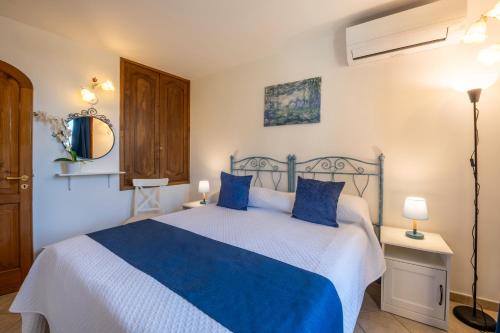 a bedroom with a blue and white bed with blue pillows at Casa Ninnì Positano in Positano