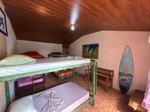 a room with two bunk beds and a surfboard at OSA SURF House in Puerto Jiménez