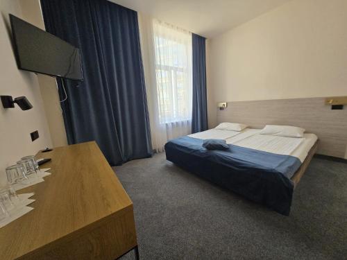 a hotel room with a bed and a desk at Hotel Astoria City Center in Iaşi