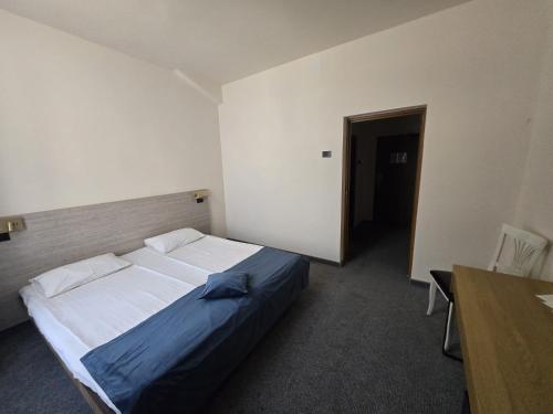a bedroom with a bed and a table in it at Hotel Astoria City Center in Iaşi