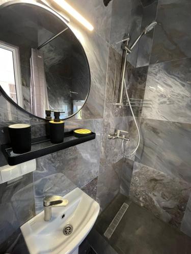a bathroom with a sink and a mirror and a shower at Zatokas Sun Club in Zatoka