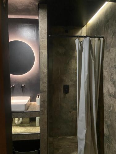 a bathroom with a shower with a sink and a mirror at Студія, апартаменти Cozy Classic in Myrhorod