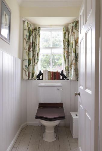 a bathroom with a toilet and a window at The Tower, Keith Marischal in Humbie