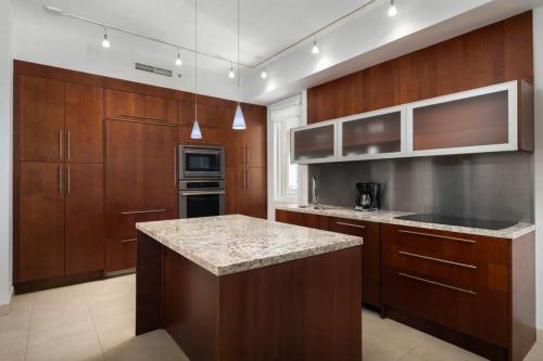 a kitchen with wooden cabinets and a granite counter top at Blue Haven Resort- All Inclusive in Grace Bay