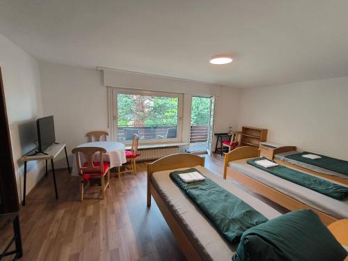 a room with two beds and a table and a window at Unterkunft Uni-nähe in Bochum