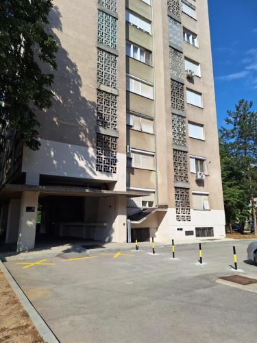 a building with a parking lot in front of it at Relax Lux apartment Nis in Niš