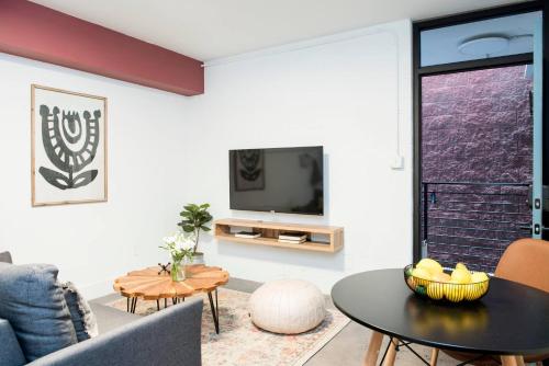 a living room with a tv and a table at *NEW* The Scarlet - Downtown | Balcony | Skyline in Atlanta