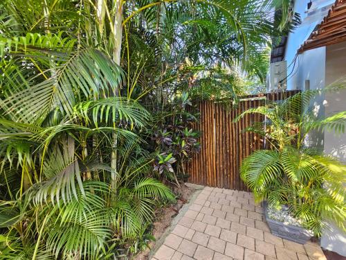 a garden with palm trees and a wooden fence at Leopard Corner Lodge in St Lucia