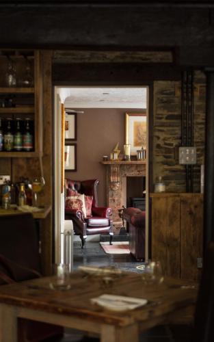 a living room with two chairs and a fireplace at The Old Mill House in Padstow