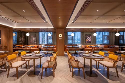 a restaurant with tables and chairs in a room at 深圳市柏寐酒店 in Sanjiaocheng